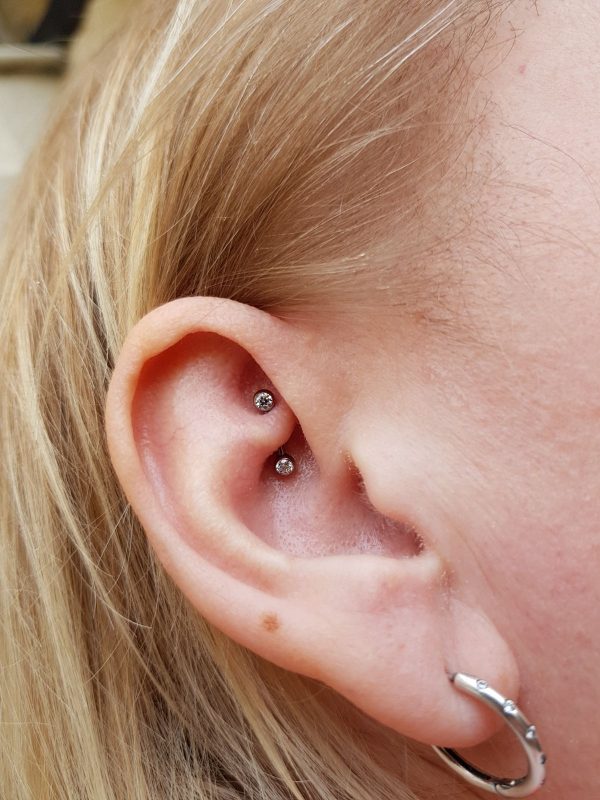 A teeny Neometal forward facing CZ gem rook piercing