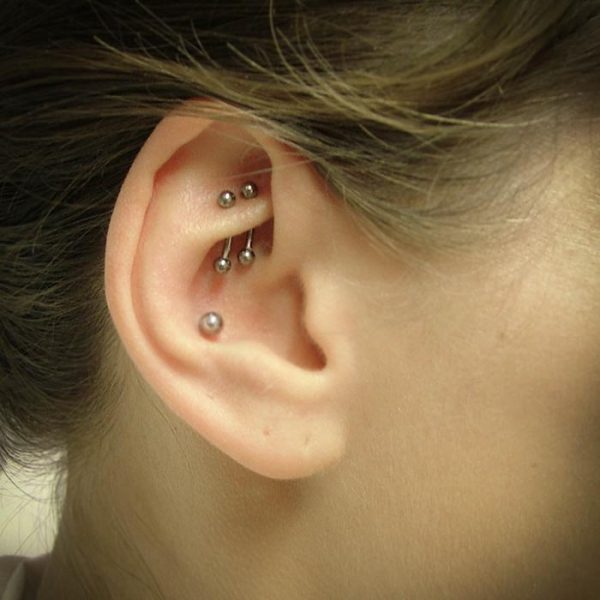 a double rook piercing wearing two side by side curved bars and a conch piercing with a plain ball