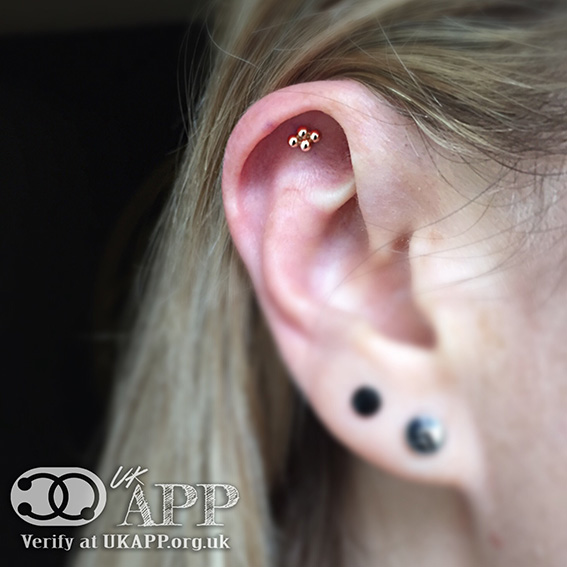 An upper helix of the ear piercing showing a larger 2mm design of the Quad bead from Anatometal