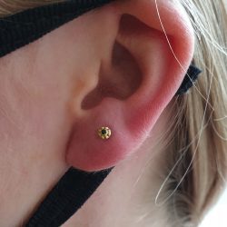 an ear wrapped in the loop of a face mask with the Tama end from Anatometal