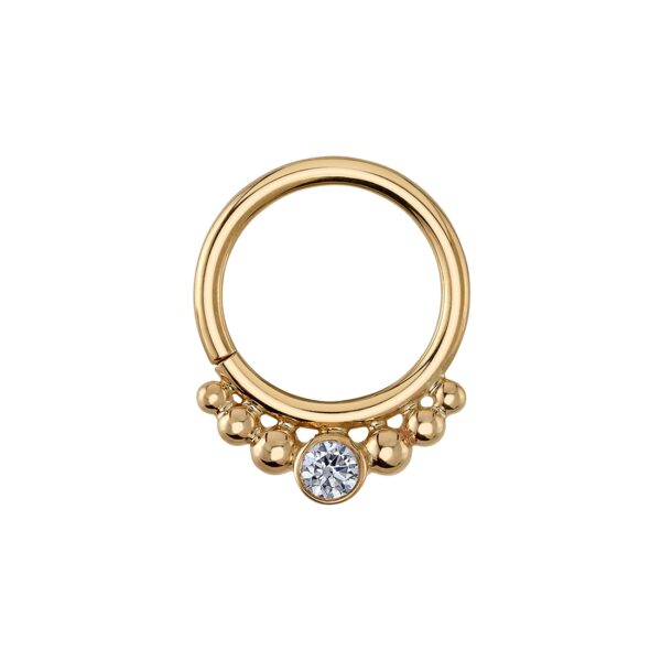 A torque seam ring with three cascading beads either side of a central gemstone setting